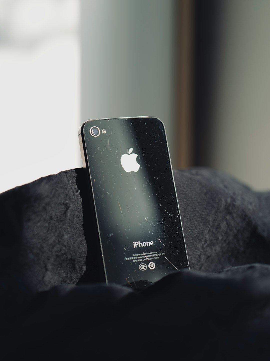 a-broken-iphone-sitting-on-top-of-a-black-blanket-riat5qmd4os